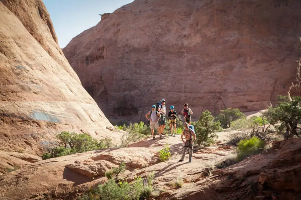 Moab tours Five people in a canyon stand with helmets and climbing gear
