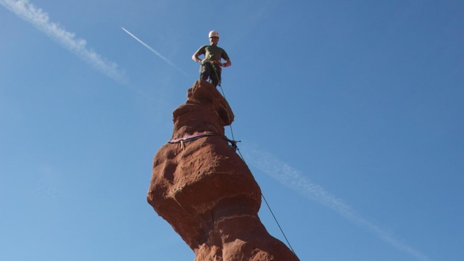 Moab rock climbing A man stands on top of the Ancient Art formation on Moab