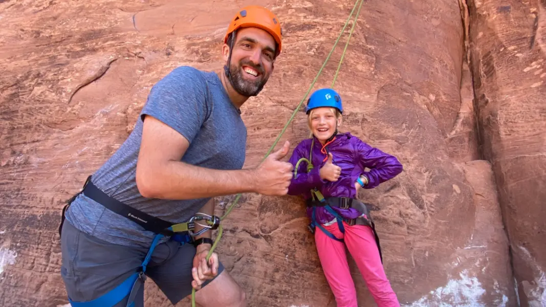 Moab utah tours a man and child in climbing gear smile for a photo