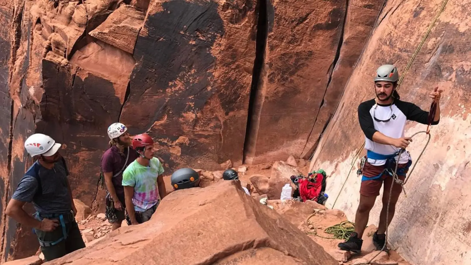 Moab tours A man demonstrates the proper climbing technique to three men.