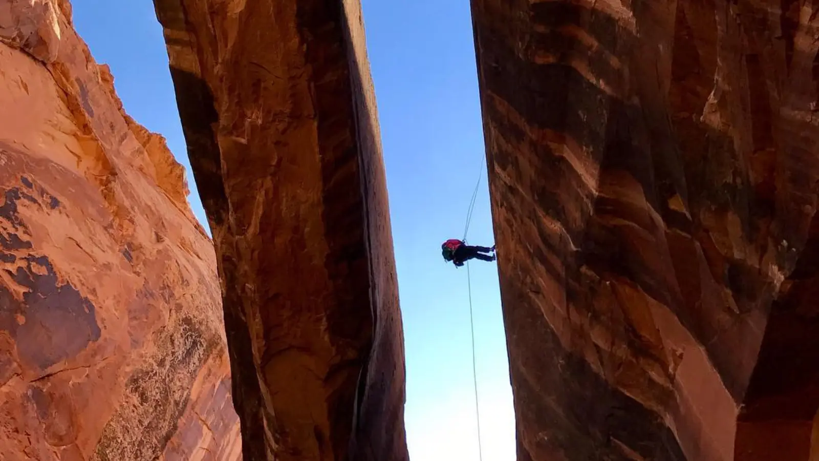 Moab utah tours A person rapells through a large arch in Moab