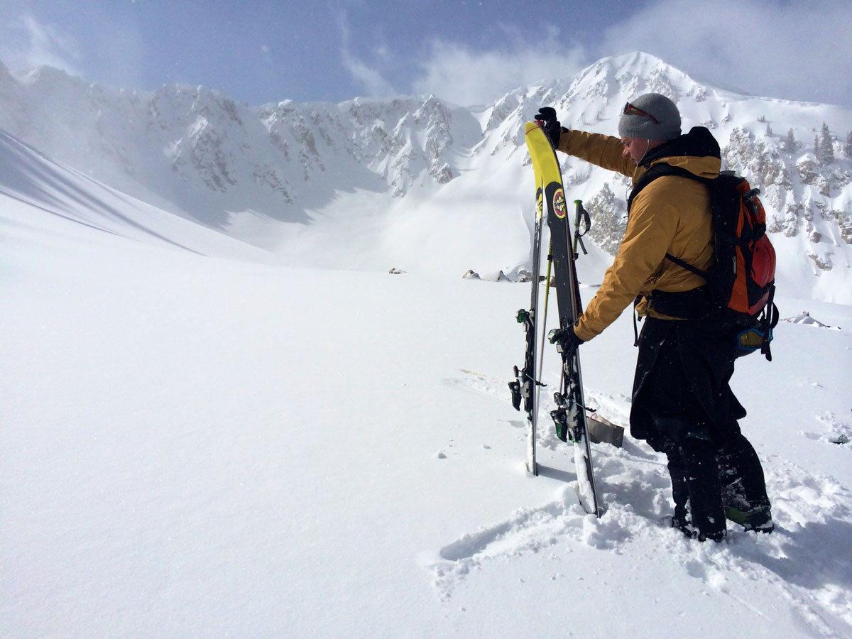 RRA ski 06 A person removes the skins from his skis with a mountain range in the background